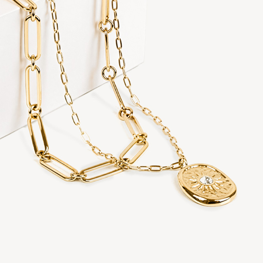 Goldene Gliederkette mit ovalem Medaillon-Anh&auml;nger, verziert mit einem eingravierten Sonnenmotiv und Kristall in der Mitte