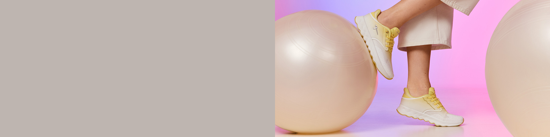 White sneakers worn on legs in front of a pink-purple background with pink balls.