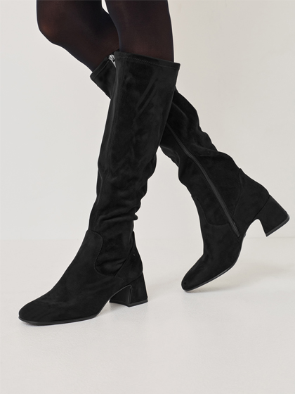 Black women's boots with a mid-height heel in a dynamic running motion on a white background
