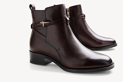 Braune Lederstiefeletten mit Absatz und goldenen Details. 