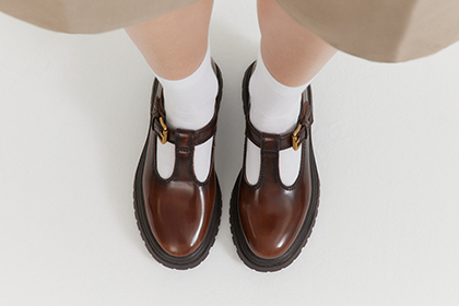 Bruine halfleren schoenen met witte sokken, van bovenaf gefotografeerd en naast elkaar gezet.