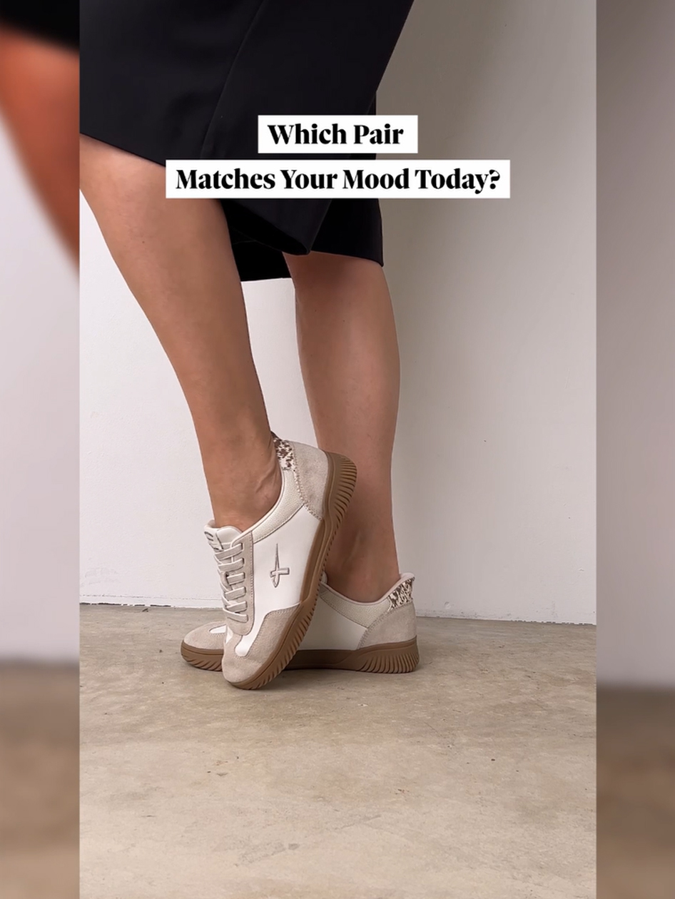 Vrouwenbenen in zwarte shorts dragen beige-witte sneakers met rubberzool.