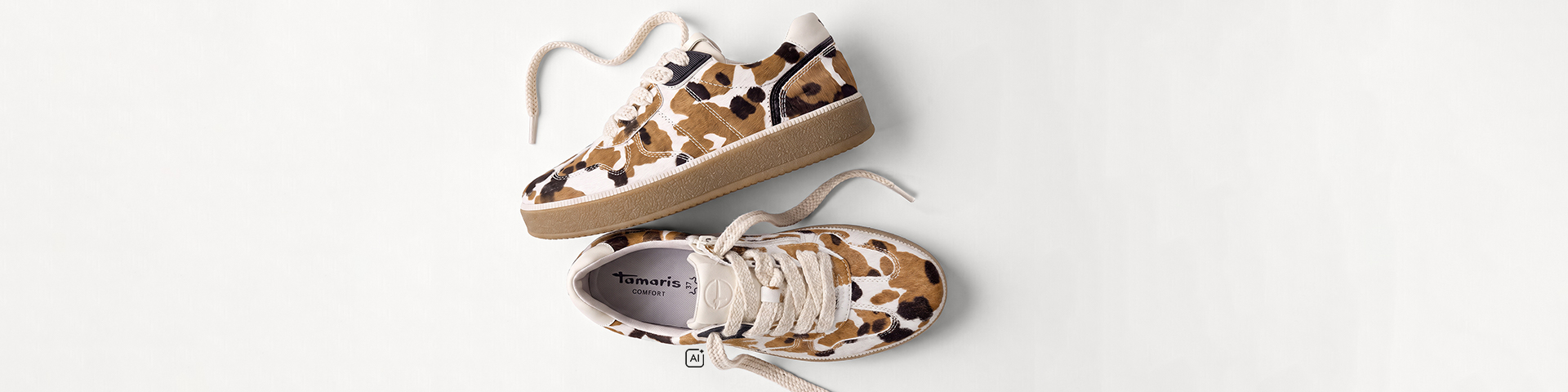 Tamaris trainer with a brown, black and white leopard print, photographed from the side and from above.