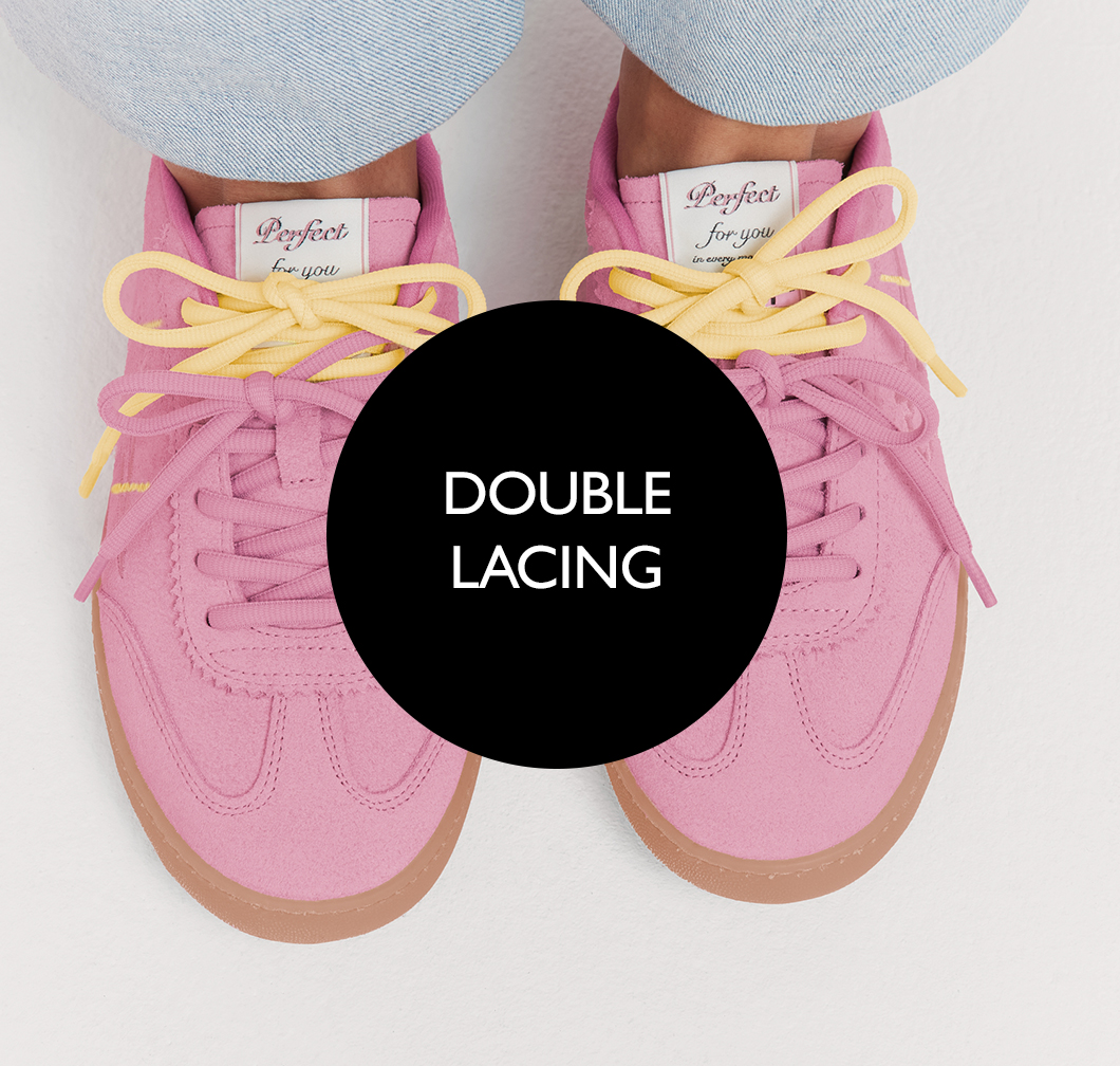 Rosa Sneaker mit doppelter Schn&uuml;rung in Pink und Gelb auf wei&szlig;em Hintergrund, mit brauner Gummisohle.