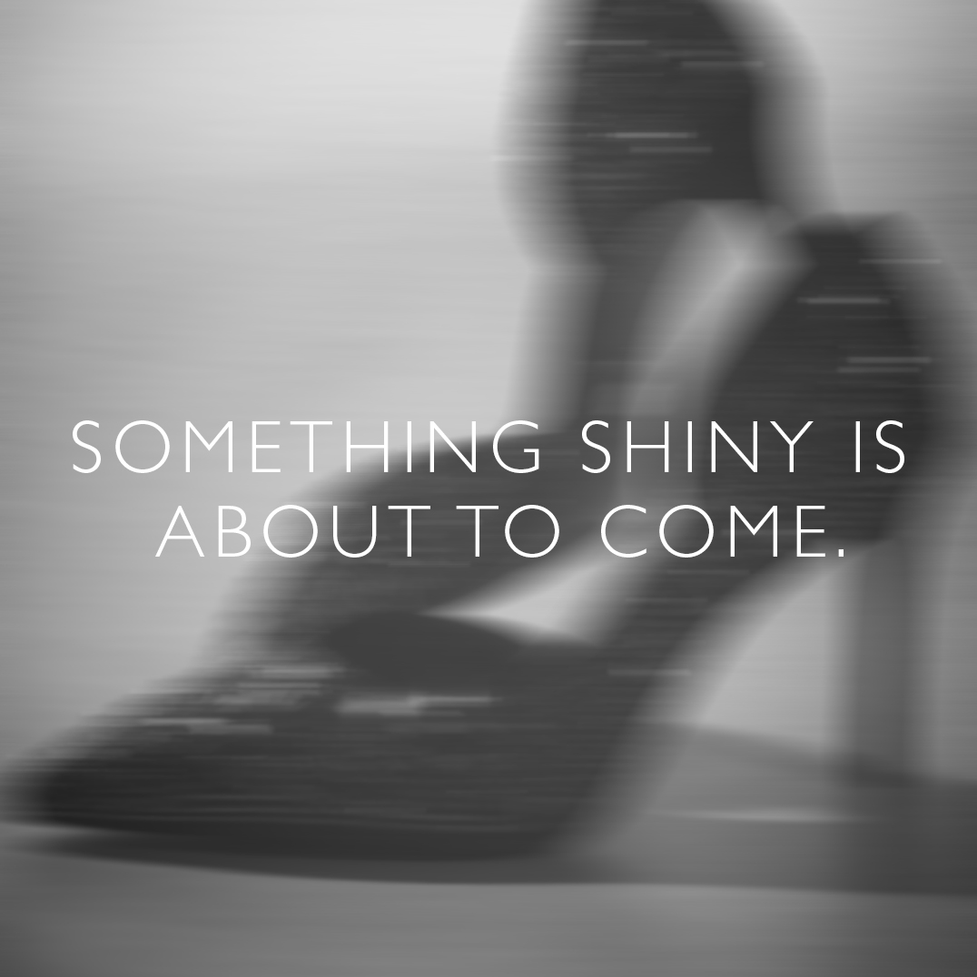 Neostr&eacute; černob&iacute;l&eacute; foto s b&iacute;l&yacute;m textem &bdquo;SOMETHING SHINY IS ABOUT TO COME&ldquo; na rozmazan&eacute;m pozad&iacute;