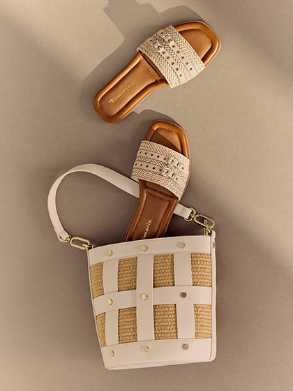 Mules Tamaris beiges avec d&eacute;tails tress&eacute;s et sac &agrave; main blanc et beige &agrave; effet panier sur fond brun clair.
