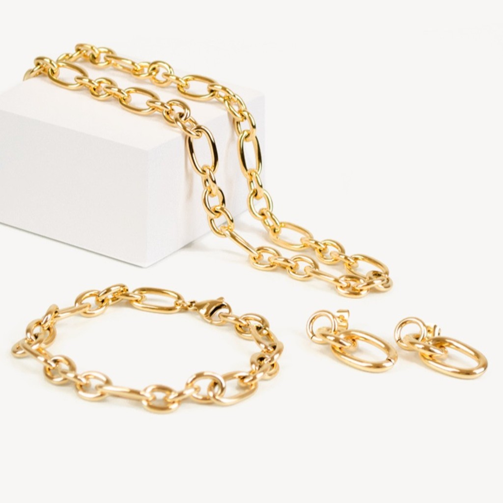 Goldenes Schmuckset bestehend aus einer Gliederkette, einem Armband und Ohrringen mit ovalen Gliedern auf wei&szlig;em Hintergrund.