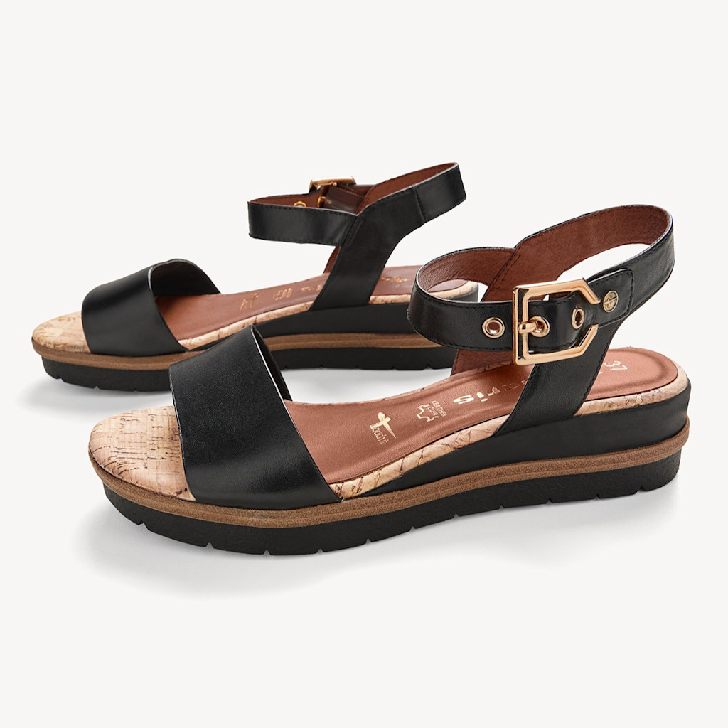 Schwarze Damen-Sandalen mit Korkfußbett, Knöchelriemen und goldener Schnalle auf weißem Hintergrund