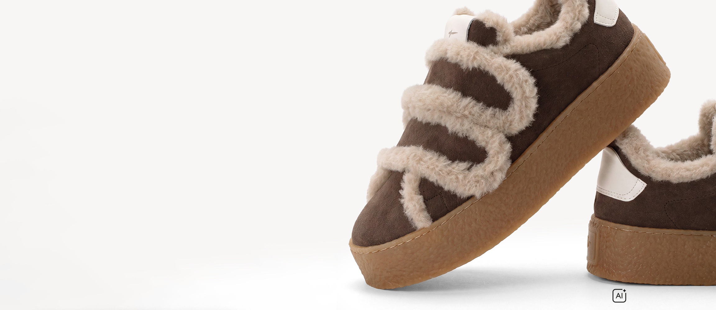 Braune Sneaker aus Wildleder mit beigen Fellverzierungen und dicker Gummisohle, Nahaufnahme auf wei&szlig;em Hintergrund.