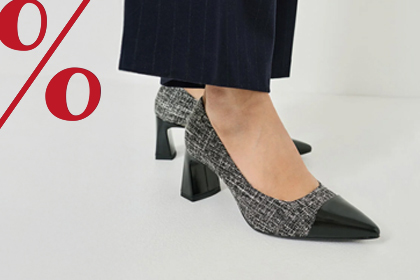 Elegantní dámské boty v černo-šedé barvě se špičatým tvarem a středním podpatkem na bílém pozadí s červenými procentními znaky.