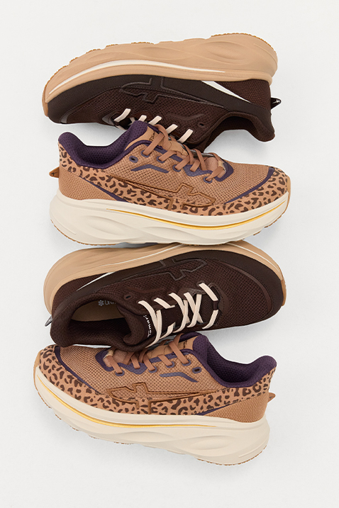 Two pairs of brown trainers with a leopard print and chunky white soles, photographed from above.
