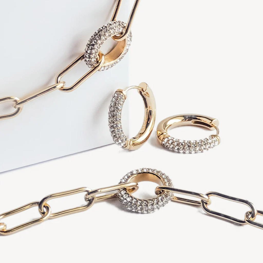 Collection de bijoux dor&eacute;s orn&eacute;s de cristaux, sur fond blanc.