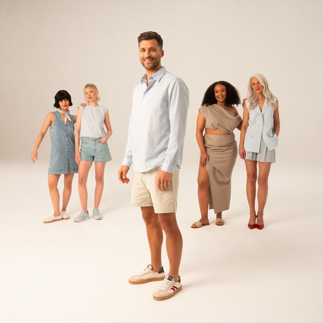 Diverse Gruppe in sommerlicher Freizeitkleidung posiert vor hellem Hintergrund in l&auml;ssiger Atmosph&auml;re.