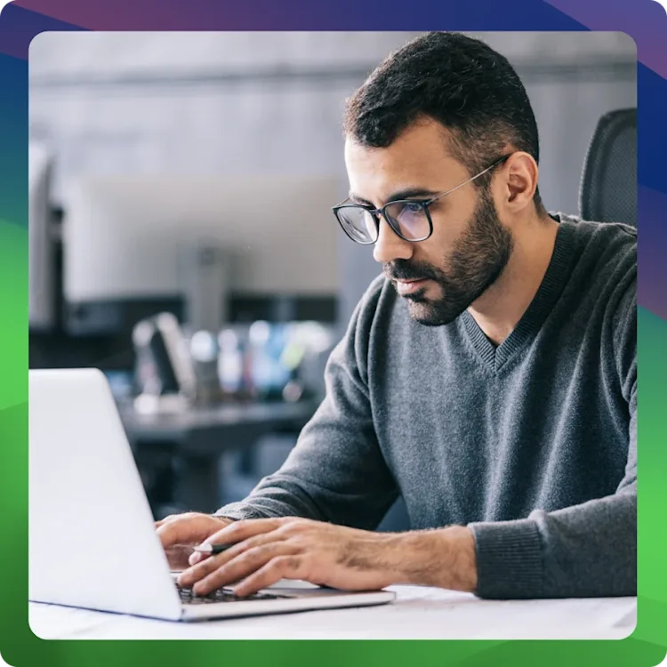 man with glasses working on laptop 