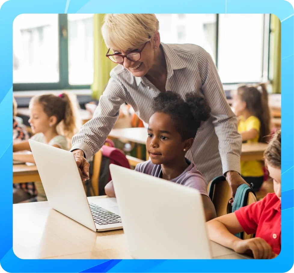 teacher helping students on laptop