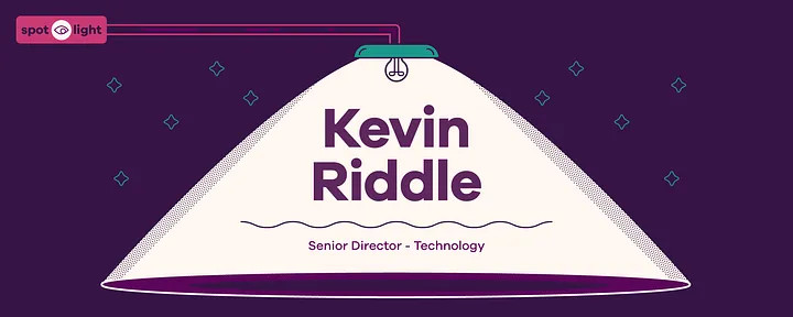 Illustration: On a dark purple background with mint green outlined stars, a pink rectangular box with a dark purple outlined eye on a white circle splits up the word "Spotlight." Two pink lines portray an arm to the top of a mint green overhead light with a dark purple outlined lightbulb illuminating a light pink area that says "Kevin Riddle, Senior Director - Technology" for this Black and Brown in Technology feature.