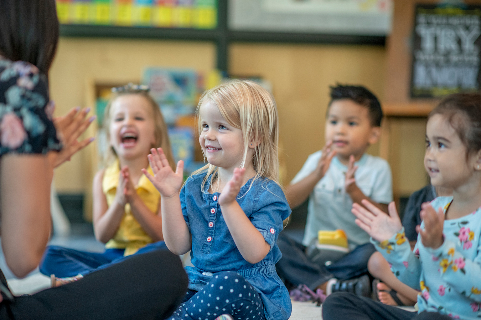 Children clapping their hands in a classroom.