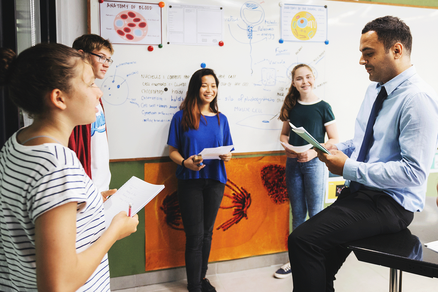 A teacher and students working together in a classroom.