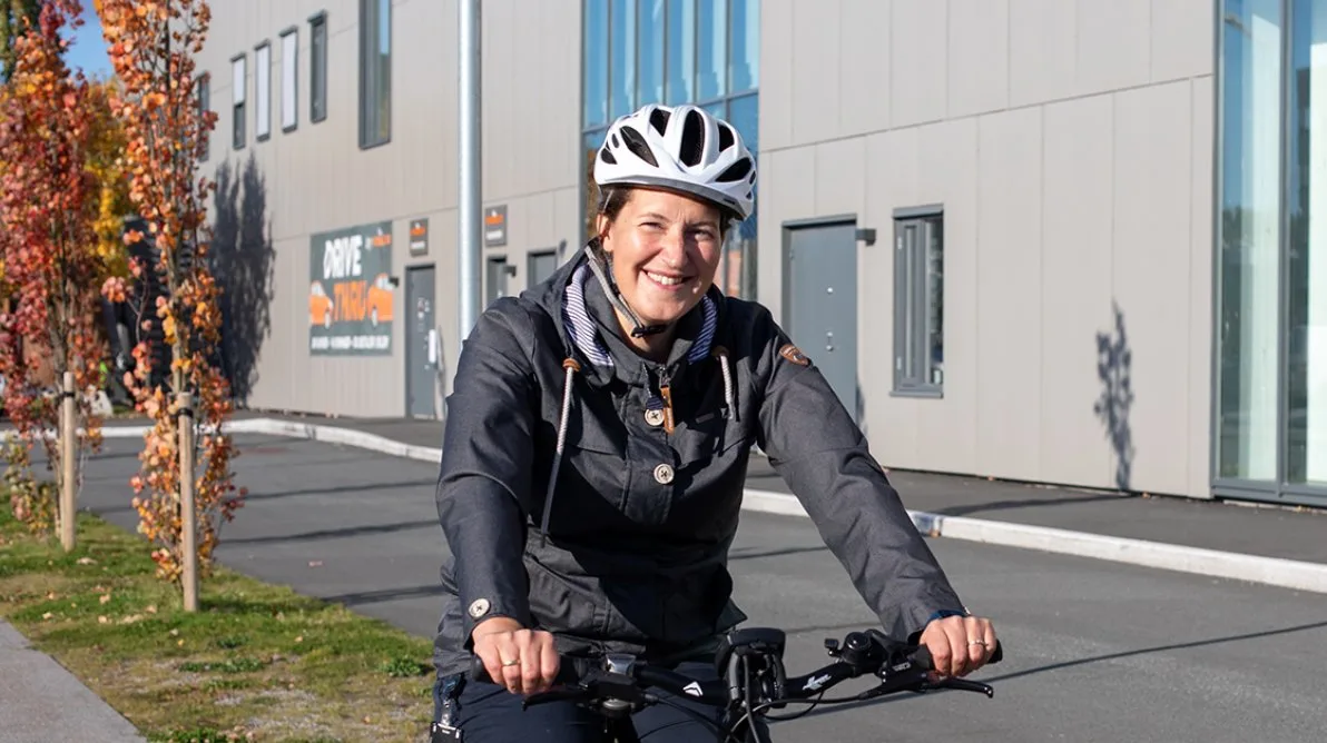 Stine på sykkel Dame sitter på en sykkel og smiler til kamera