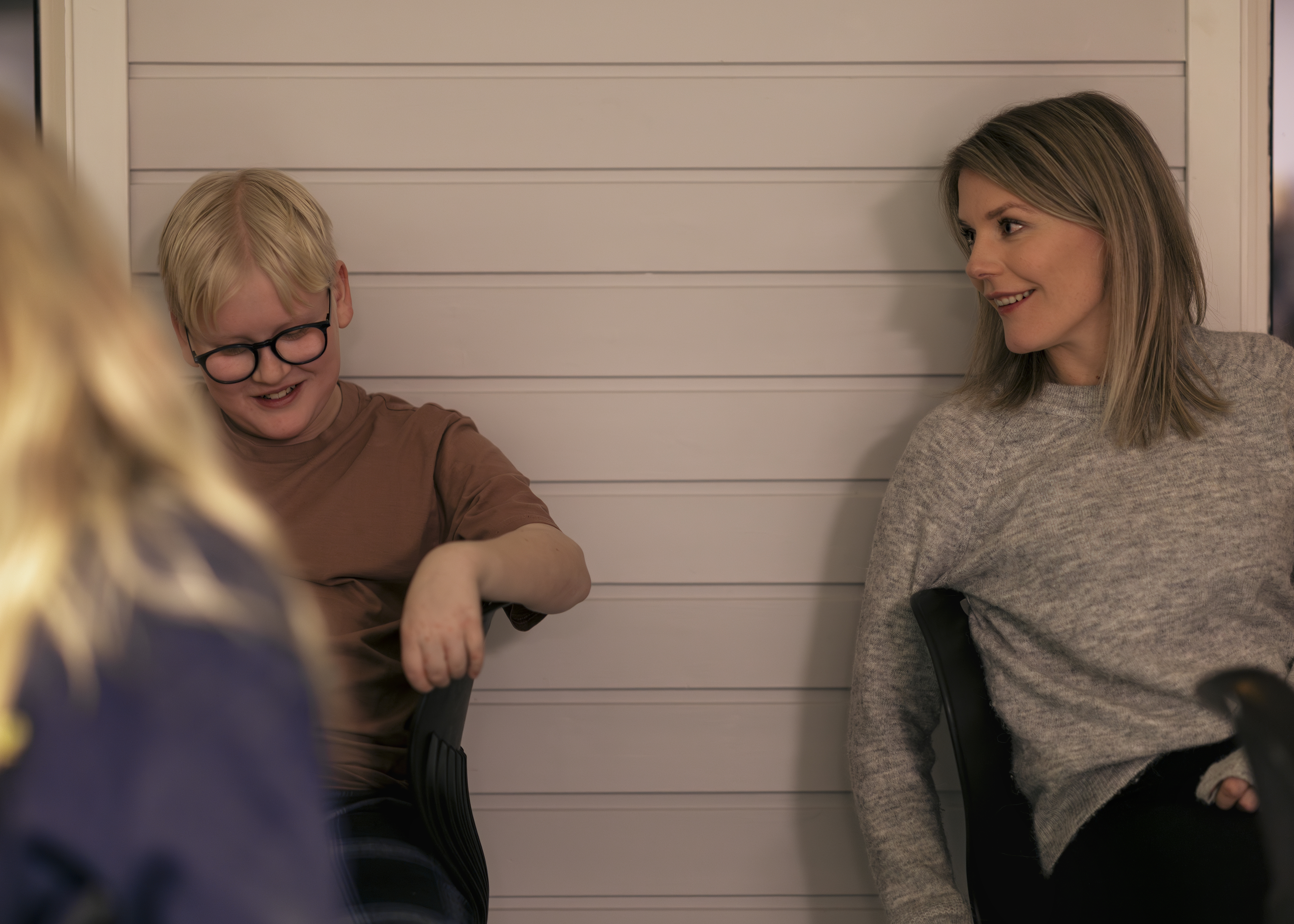 En ung gutt og en voksen dame i leende samtale