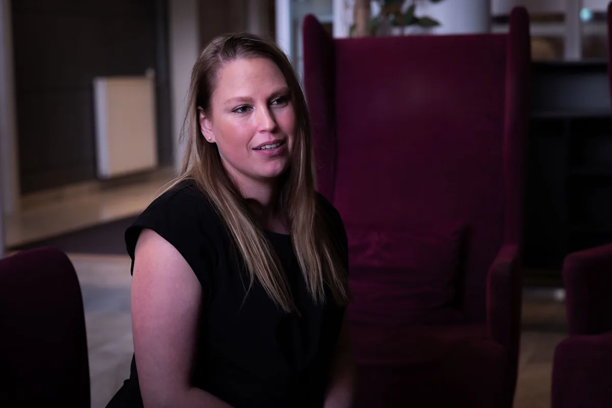 rikke strandvik Kvinne med langt hår sitter på en sofa