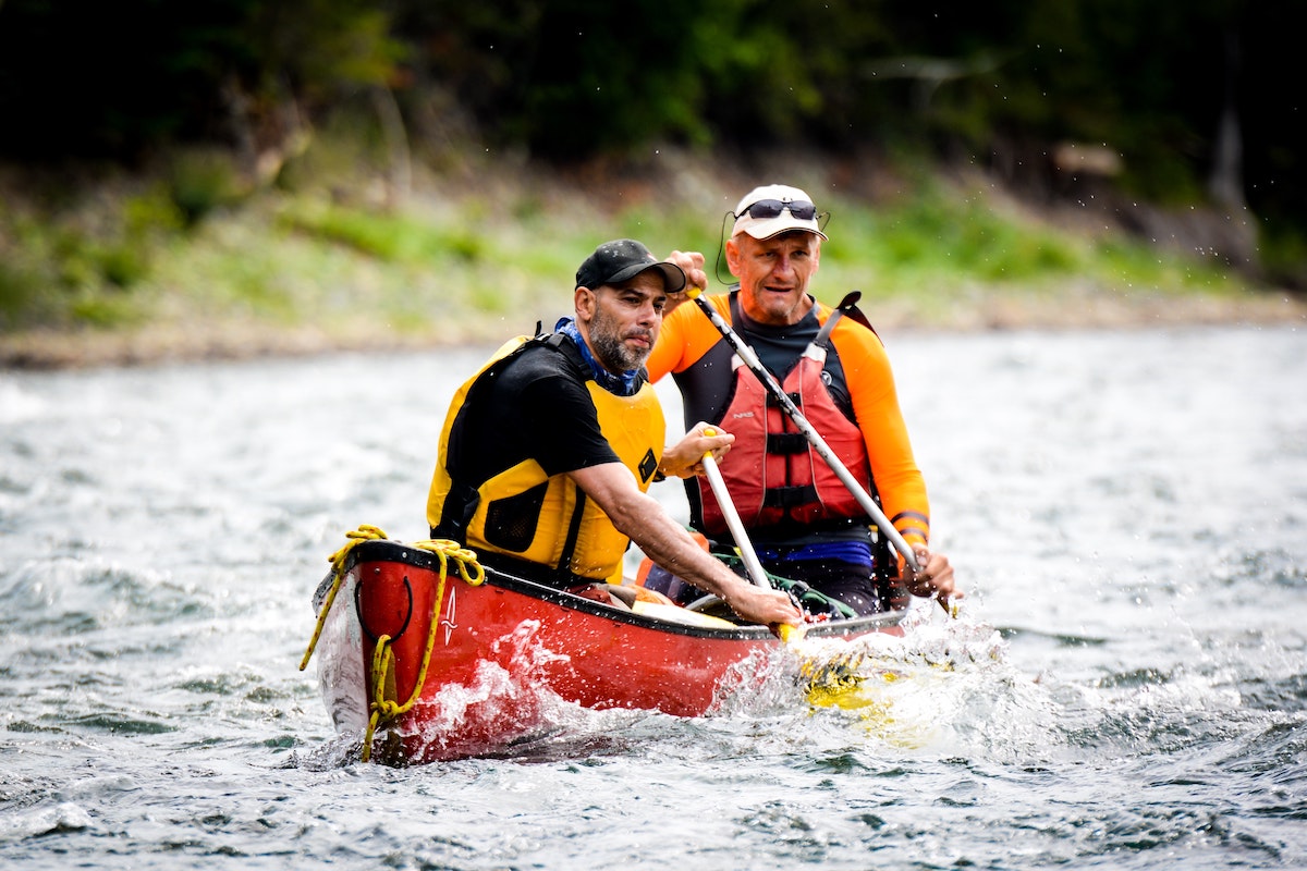 To menn med redningsvester i en kamp på veg ned ei elv
