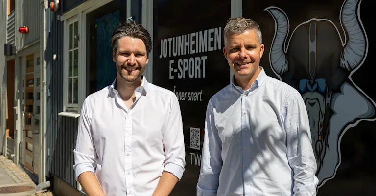 To smilende menn utenfor lokalene til Jotunheimen e-sportsenter To smilende menn utenfor lokalene til Jotunheimen e-sportsenter