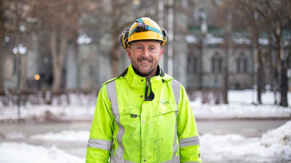 NTE ansatt i refleksjakke smiler til kamera