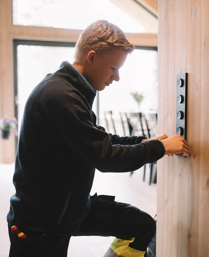Elektriker som monterer lysbrytere på en vegg Elektriker som monterer lysbrytere på en vegg