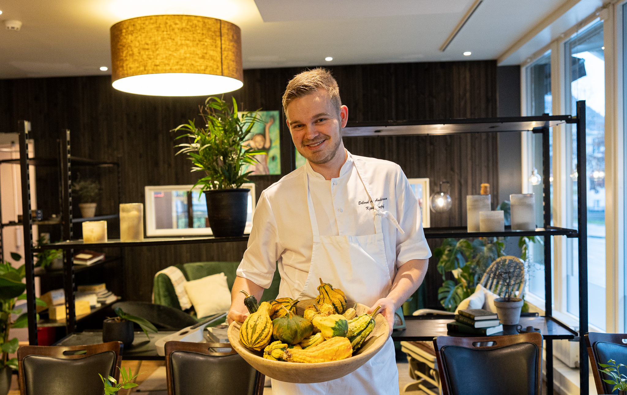 Blid mannlig kokk holder et fat med gresskar