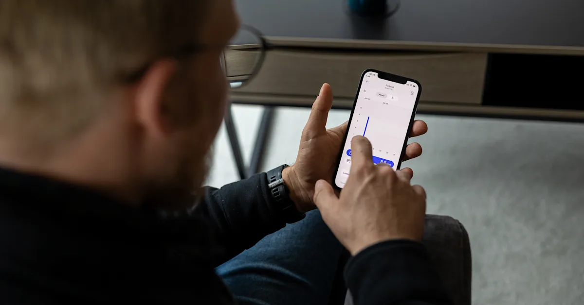 Mitt NTE-appen viser forbruksdata elbillading Mann holder en mobil som viser forbruksdata på elbillading