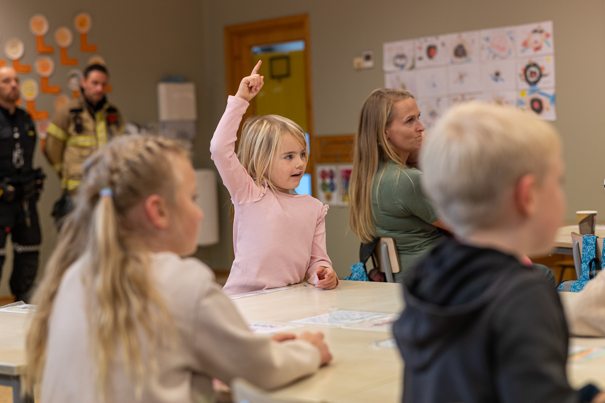 Jente rekker opp hånda i klasserommet