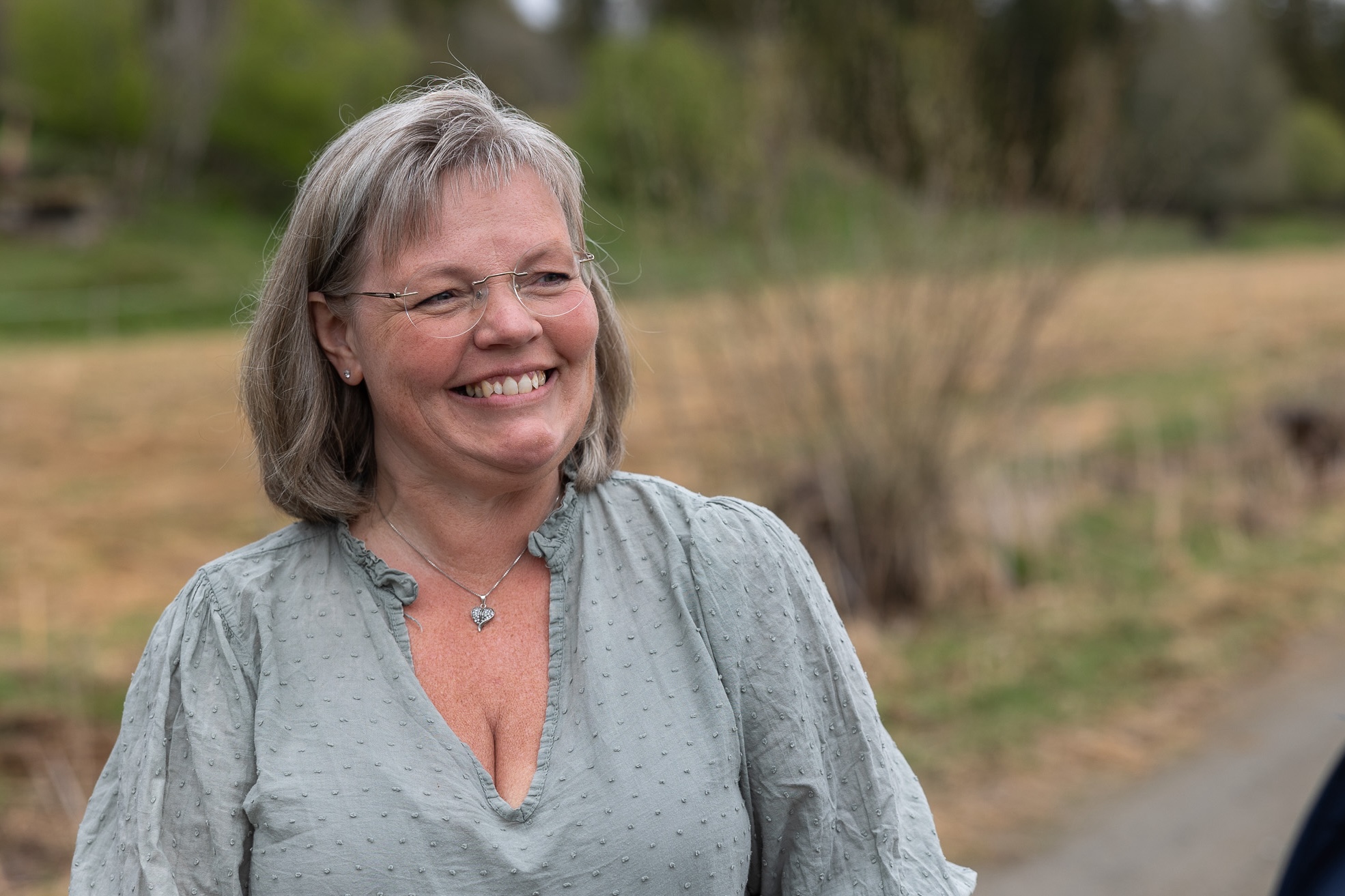 Smilende dame  på en skogsvei