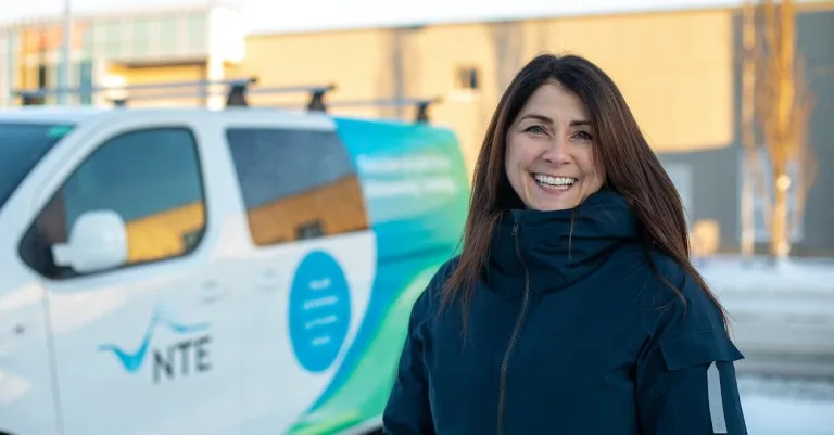 Marit Gystøl Marit foran en av NTE sine elektriske varebiler