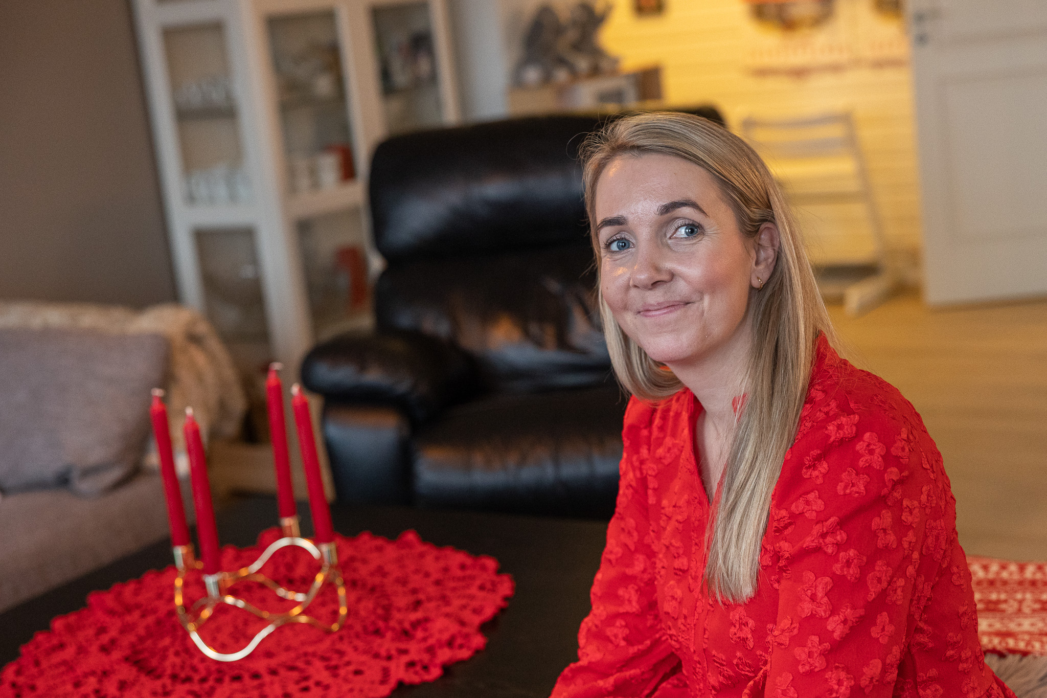 Smilende kvinne i en julepyntet stue