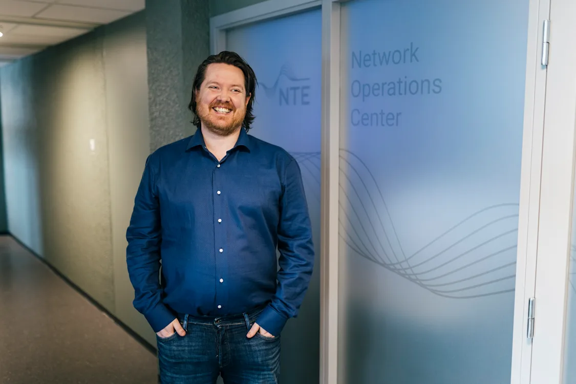 arild hembre utenfor NOC-en Smilende mann utenfor en dør det står Networks operations center på