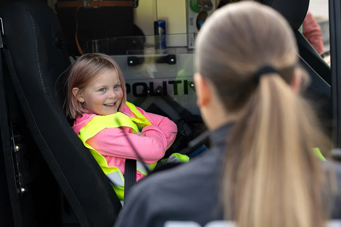 jente i politibil jente med refleksvest sitter inne i en politibil