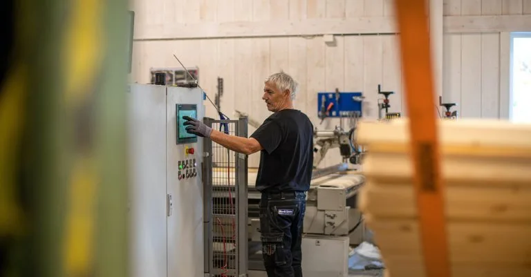 arbeidskar Mann trykker på en skjerm installert på en fabrikkmaskin