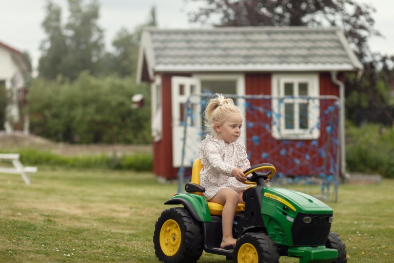 Barn som sitter på en liten traktor