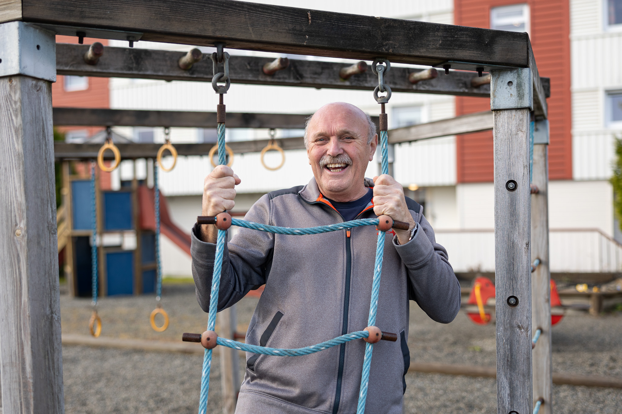 Smilende mann i et lekestativ