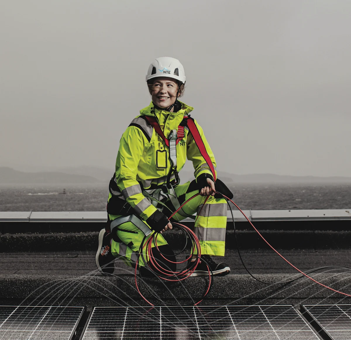 Kvinnelig montør installerer solceller på taket. Kvinnelig montør installerer solceller på taket.