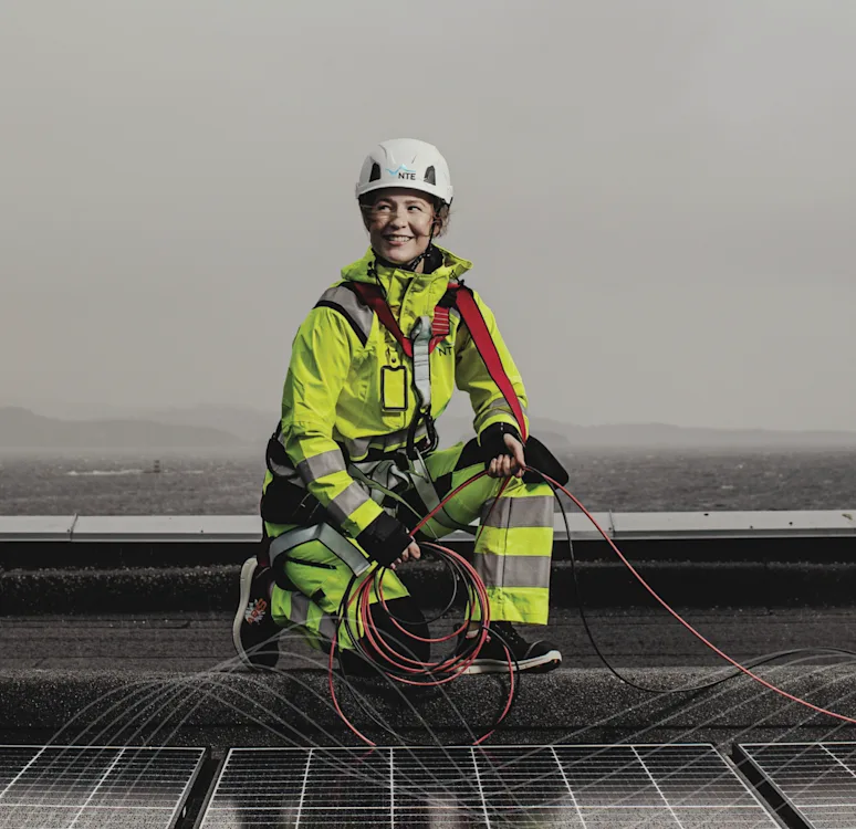Kvinnelig montør installerer solceller på taket. Kvinnelig montør installerer solceller på taket.