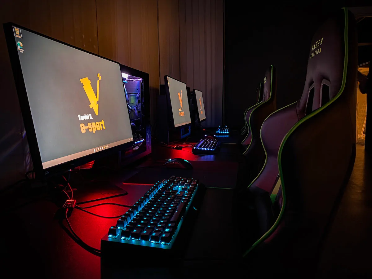 esportutstyr Gaming-pcer med tastatur står på et bord med gamingstoler bak