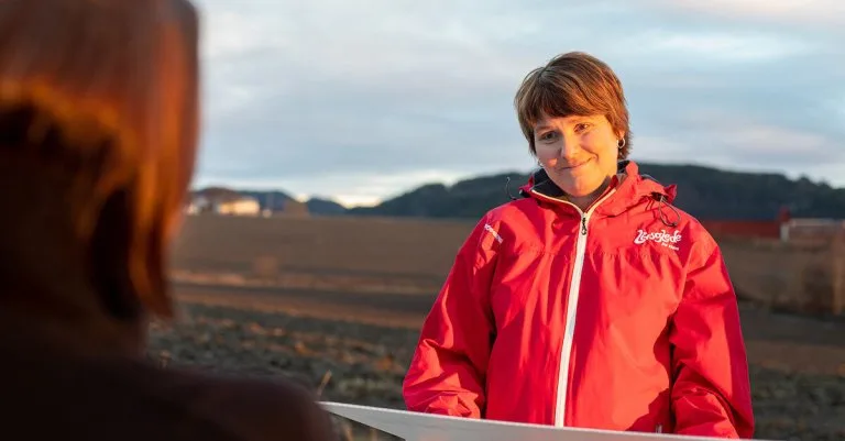 margrete Dame som smiler mens hun ser på en annen person utenfor bildet