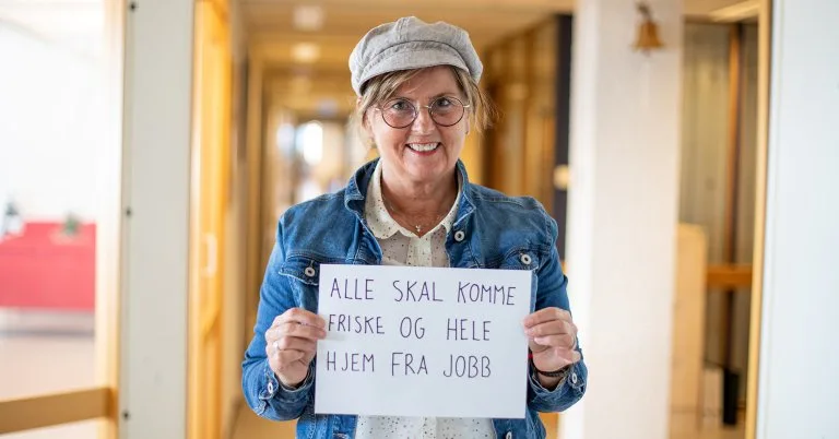 Gunn Elisabeth Gunn Elisabeth holder en plakat som sier "Alle skal komme friske og hele hjem fra jobb"