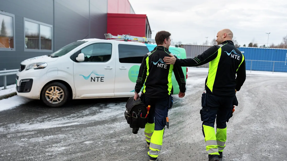 To elektrikere som går mot sin NTE arbeidsbil To elektrikere som går mot sin NTE arbeidsbil