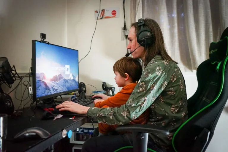 Fredrik gamer med sønn Far sitter å gamer med sønnen i fanget