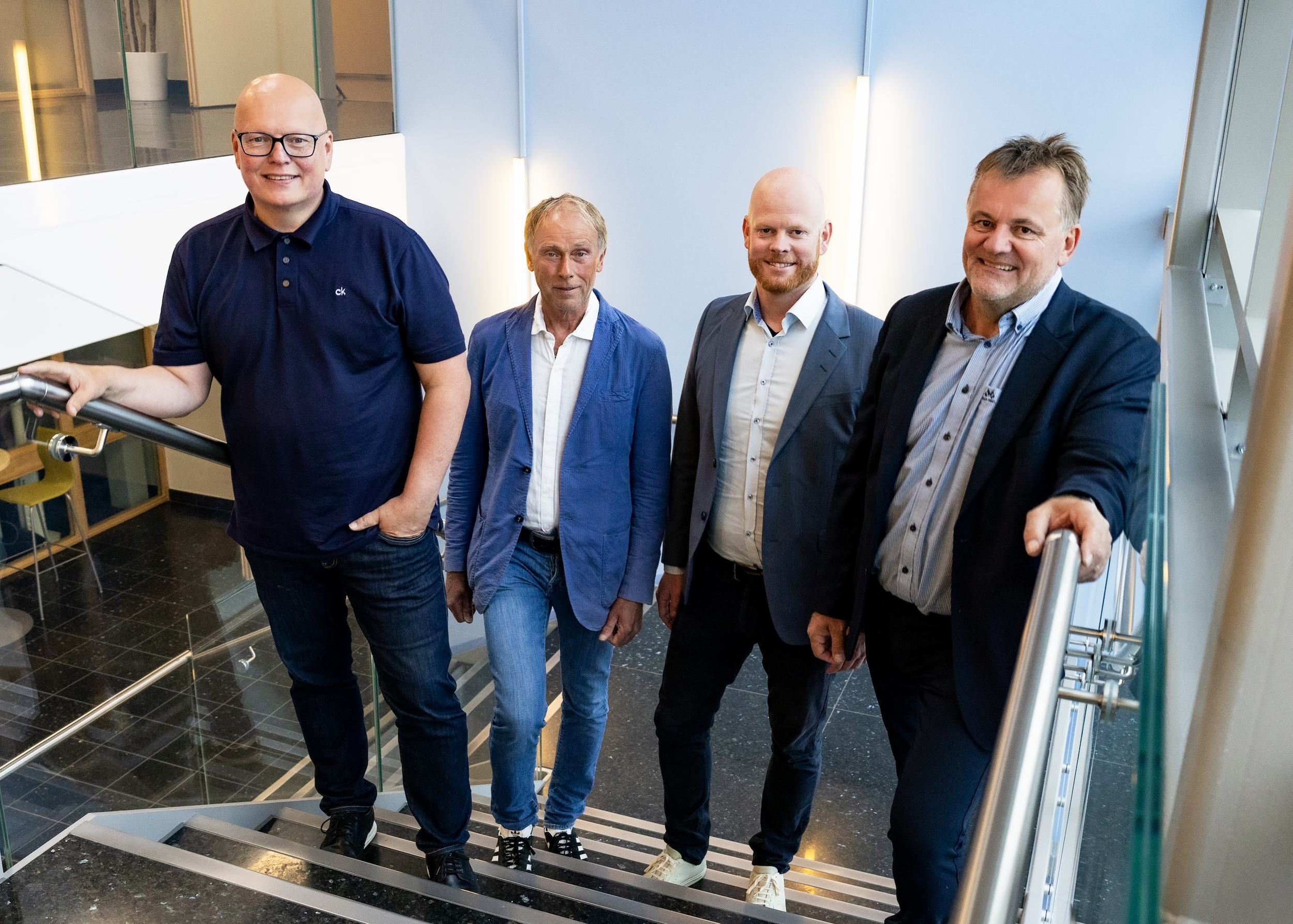 Fire menn står i en trapp