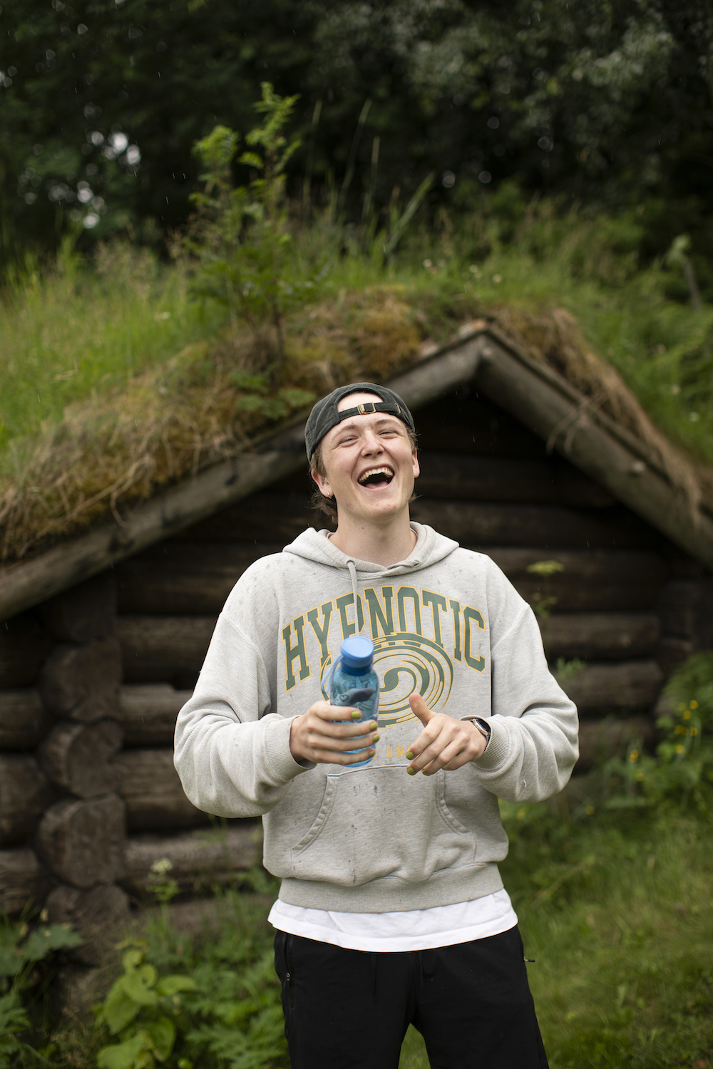 Lattermild gutt som holder en vannflaske