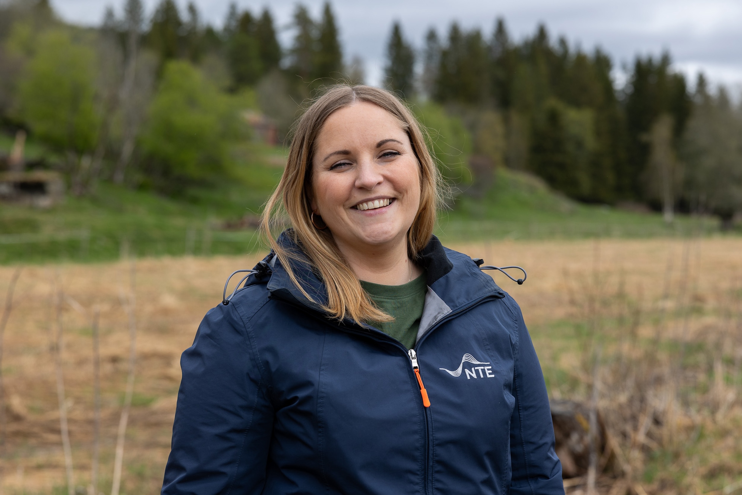 Smilende dame med NTE-logoen på jakka